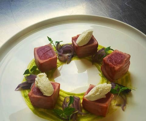 Cubes of seared tuna in a ring on a green pea purée