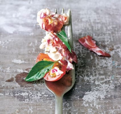 Lobster, tomato and basil arranged along a fork